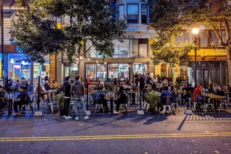 Uma multidão desfruta de comida e bebida ao longo da Valencia Street, em São Francisco