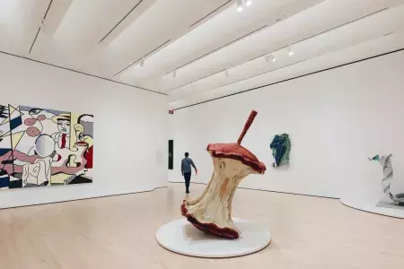 Um homem caminha por uma grande e arejada sala de exposição repleta de arte moderna no SFMOMA. São Francisco, Califórnia.