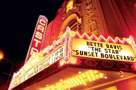 The neon marquee and sign for the Castro Theatre is lit up at night.