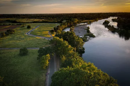 Image of green area and waterway next to it during sun set 