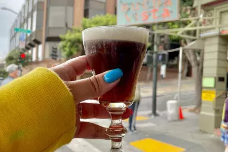 有名なブエナ ビスタ カフェの外でアイリッシュ コーヒーを楽しむ訪問者