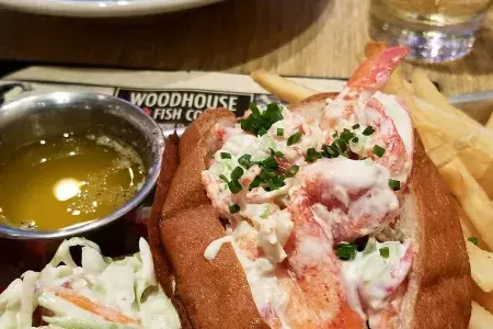 Up-close image of lobster roll with a side of fries