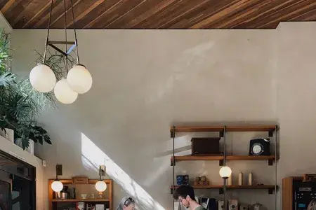 Man making coffee for woman at sunlight coffee-shop counter