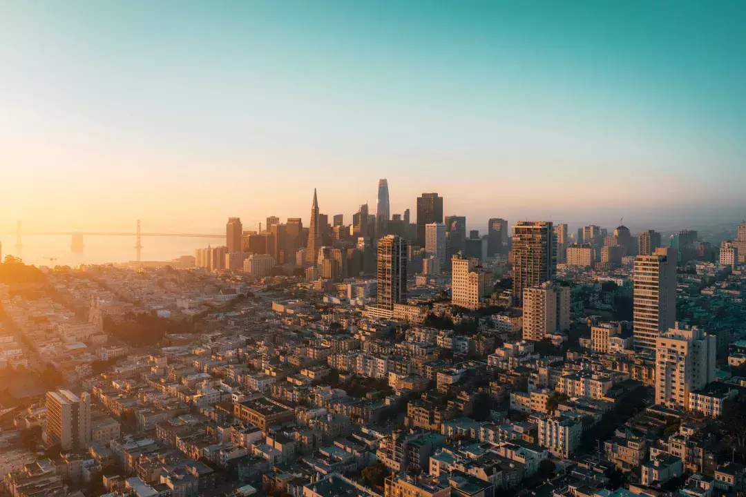 The skyline of San Francisco is seen from the air in a golden light.