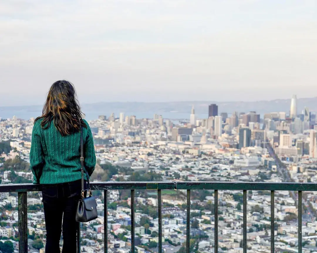 Uma mulher olha para o horizonte de São Francisco de Twin Peaks.