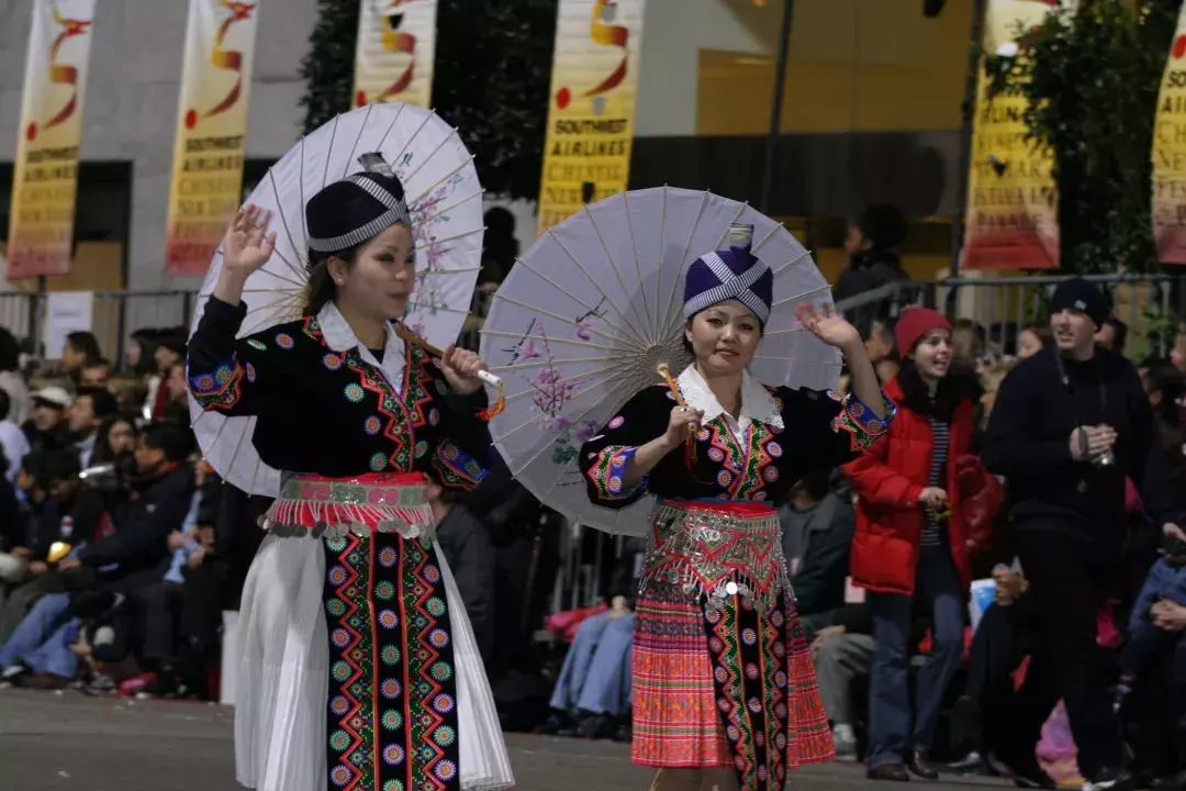 Two women in traditional dress walk in the San Francisco Chinese New Year celebration parade.