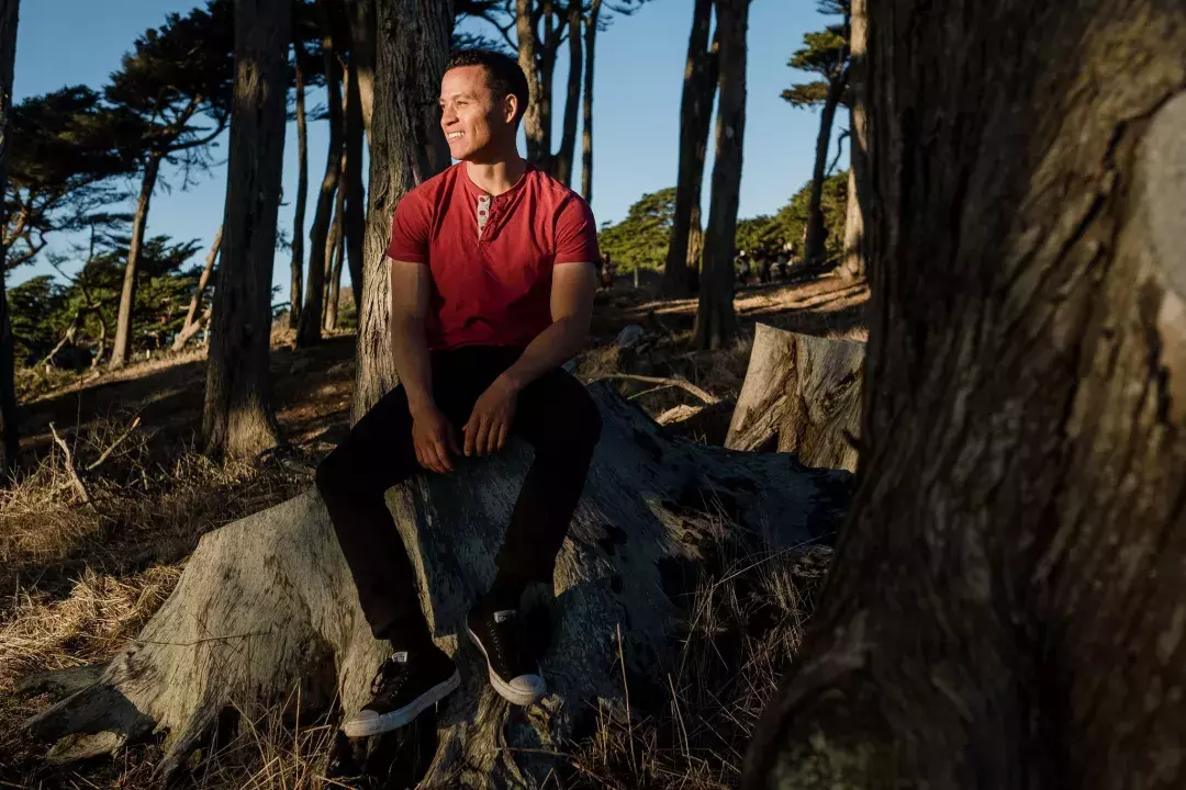 Nick Whittlesey sitting on a tree stump.