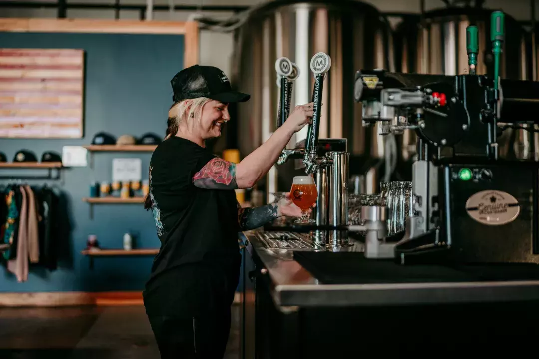 Woman pouring beer into a glass in a brewery