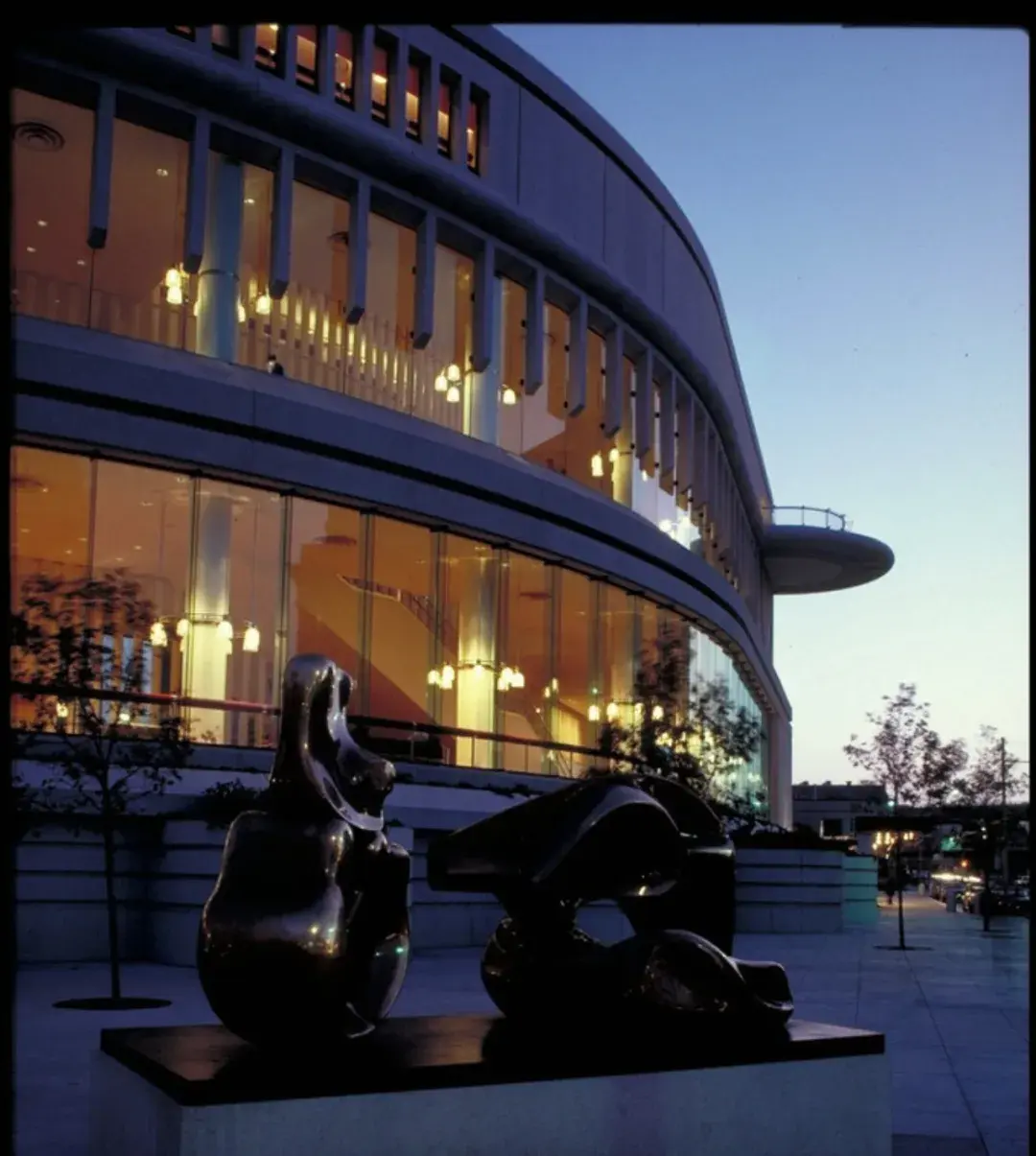 Sculpture in front of symphony hall lit up at night
