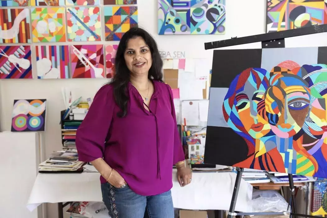 Woman standing in front of her artwork 