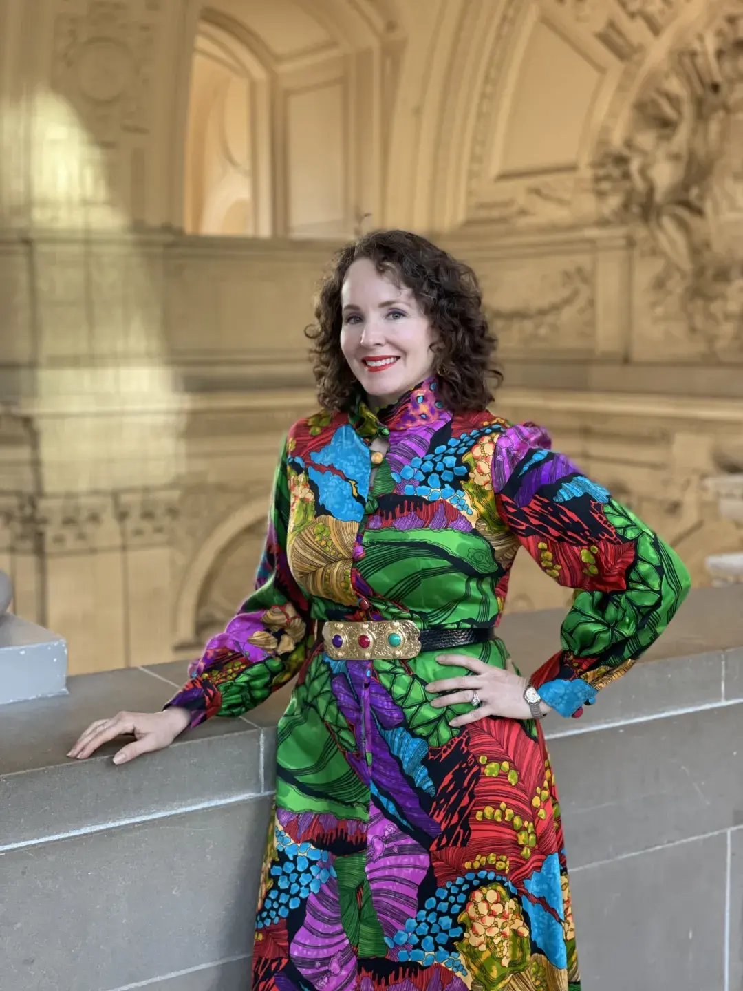 Kate Patterson posing in a colorful dress inside City Hall. 