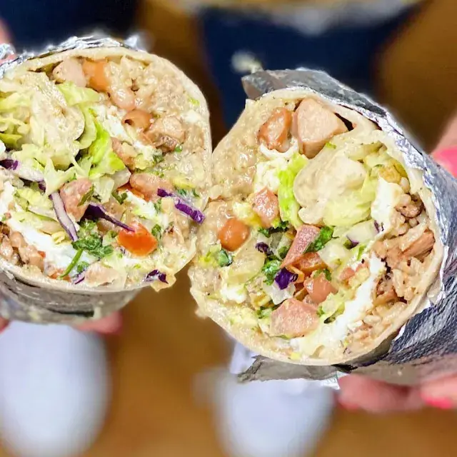 missionスタイルのブリトーをホイルでapp 、半分に切ってカメラに見せる。