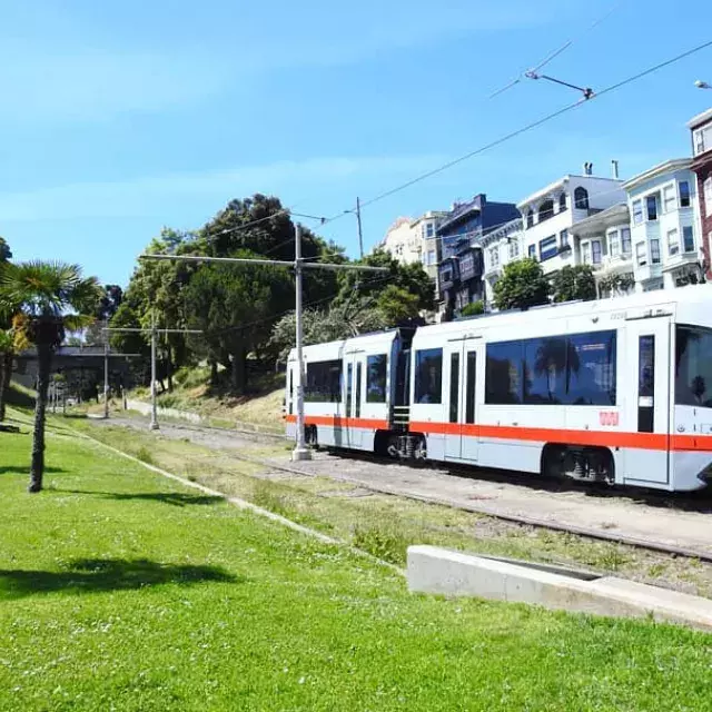 A MUNI passenger train runs along a track in San Francisco.