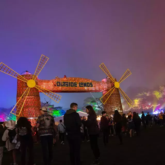 A crowd of festival-goers are pictured at night amid neon lights at the Outside Lands music festival in San Francisco.