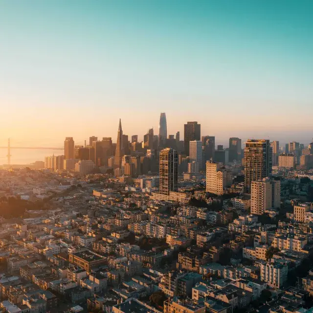 The skyline of San Francisco is seen from the air in a golden light.