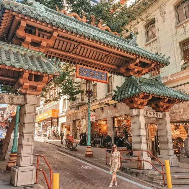 サンフランシスコのChinatownの入り口を示す華やかな門の前でポーズをとる女性。