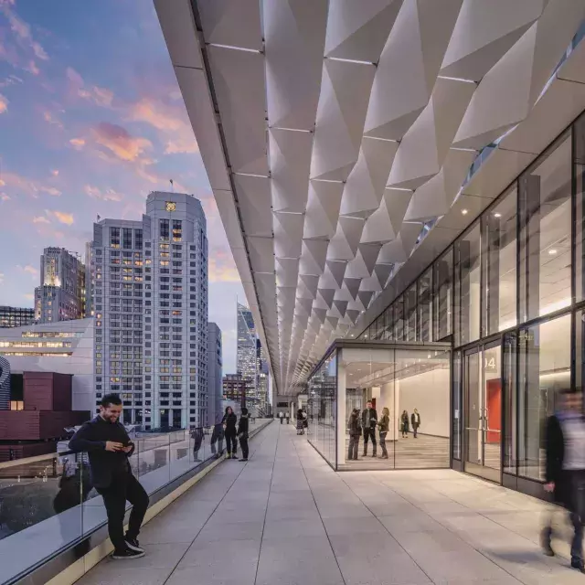 Meeting attendees stand and stroll on a balcony at Moscone Center South in San Francisco.