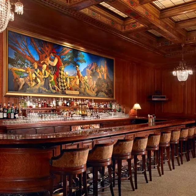 The bar at the Palace Hotel, which features wood-paneled walls and a painting titled The Pied Piper of Hamelin.