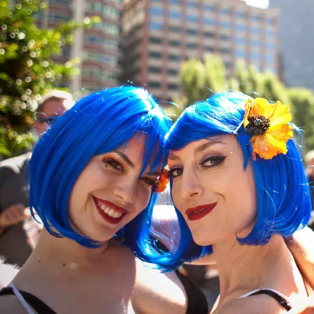 Two women sporting blue wigs attend San Francisco Pride.