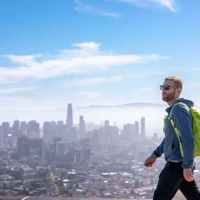 A visitor hikes to the top of Twin Peaks with his backpack.