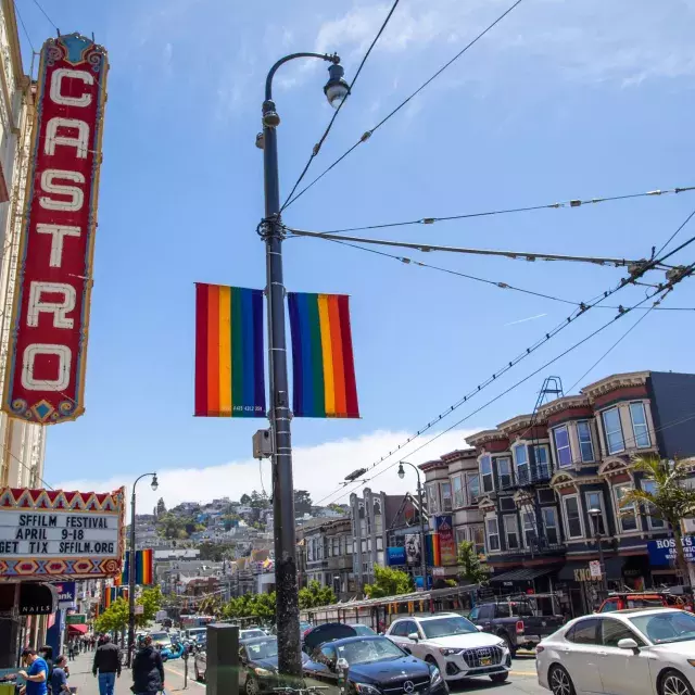 O bairro Castro, em São Francisco, com a placa do Teatro Castro e bandeiras arco-íris em primeiro plano.