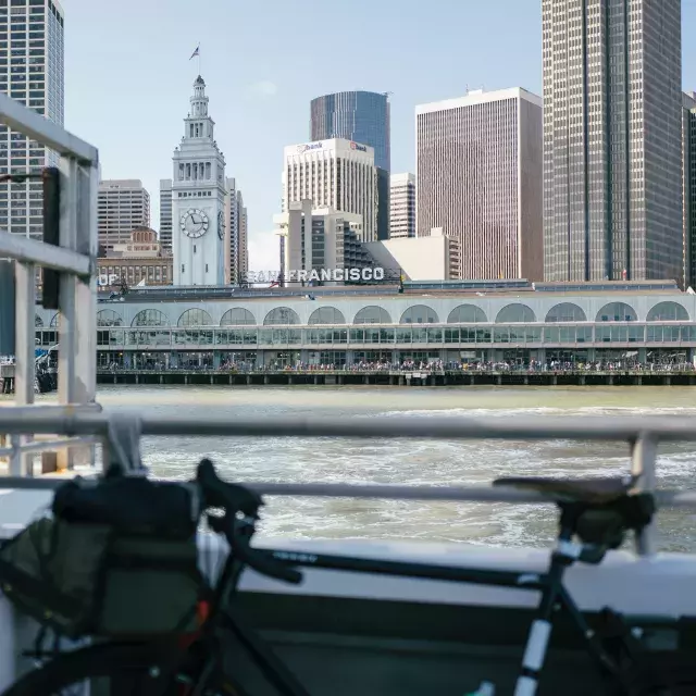 Bike leaning against a rail with the Ferry Building in the background.