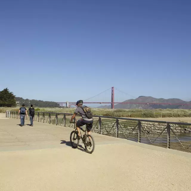 Um homem anda de bicicleta por uma trilha em Crissy Field. São Francisco, Califórnia.