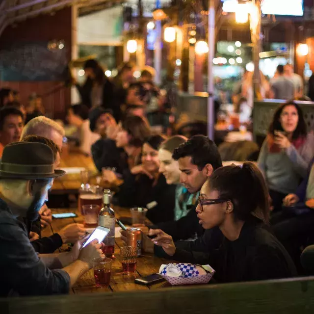 People eating in a crowded dining area in SoMa. San Francisco, California.