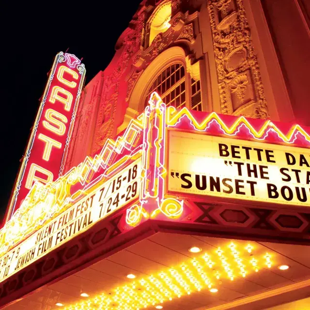 The neon marquee and sign for the Castro Theatre is lit up at night.