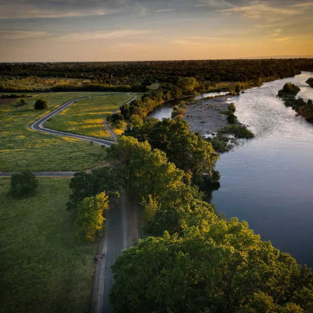 Image of green area and waterway next to it during sun set 