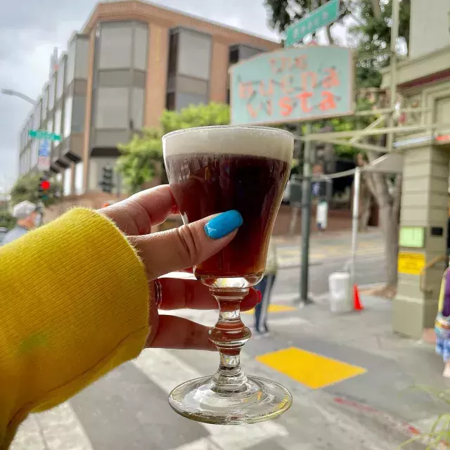 A visitor enjoys an Irish coffee outside the famous Buena Vista Cafe