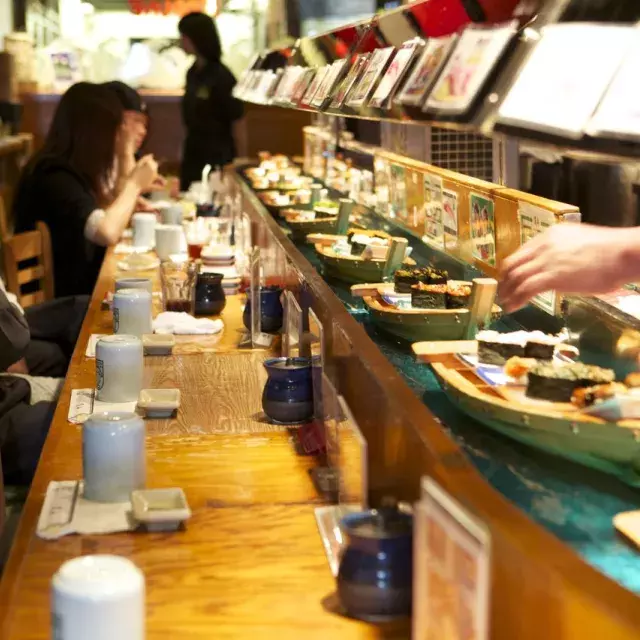 Imagem de sushi passando em mini-barcos