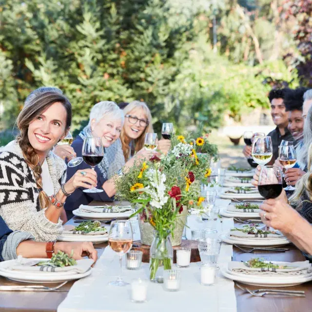 Amigos em uma mesa compartilhando uma degustação de vinhos ao ar livre