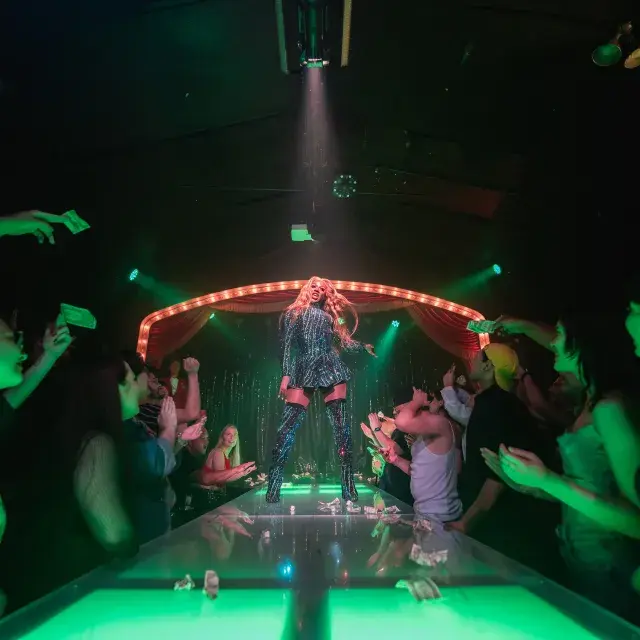 オアシスのステージで観客の前で踊るドラッグパフォーマー