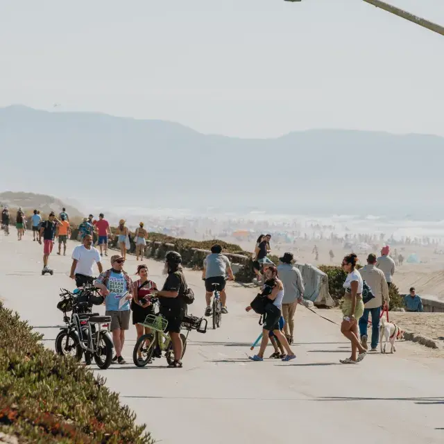 Visitors explore Sunset Dunes on a bright, sunny day.