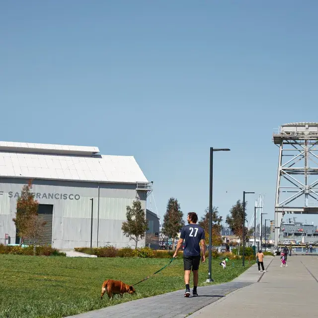 A man walks his dog in Crane Cove Park in San Francisco's Dogpatch neighborhood.