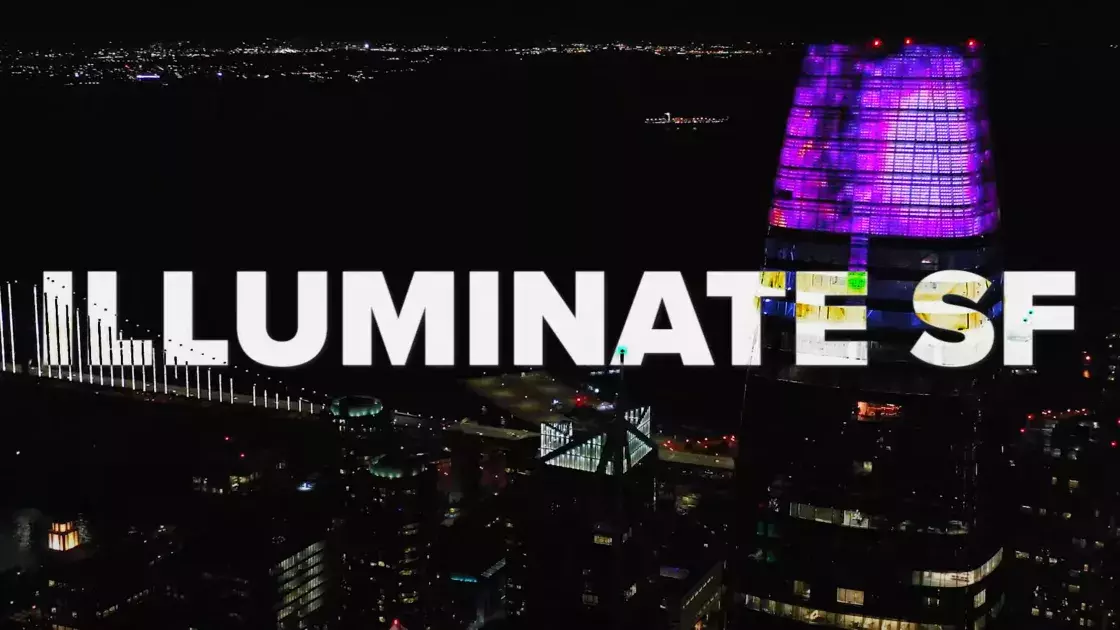 The Bay Bridge and Salesforce Tower illuminated at night with the words "Illuminate SF"